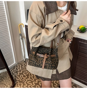 Detail der Bucket-Bag mit Leopardenmuster, braunem Lederriemen und Metall-Dornschließe
