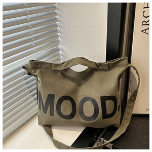 Dettaglio della borsa tote in tela verde militare con stampa MOOD e tracolla