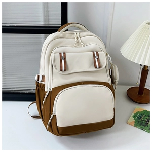 Detailed view of the multi-pocket school backpack with a stylish small round pendant