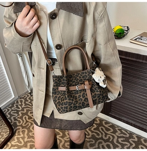 Detailansicht der Leopard-Tasche mit braunen Ledergriffen und weichem Anhänger