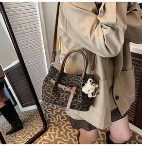 Modische Bucket Bag mit Leopardenmuster, Lederriemen und Plüschtier-Anhänger im Detail