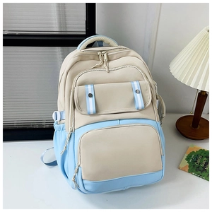Detail of beige and blue backpack with multiple pockets and adjustable side buckles