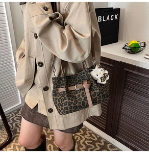 Detailaufnahme der Leoparden-Eimertasche aus Canvas mit Ledergriffen und Kitty-Anhänger
