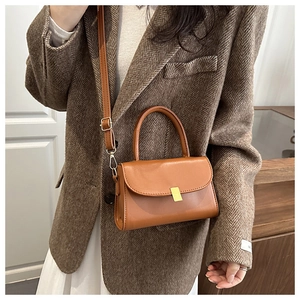 Brown vintage square handbag shown styled with a classic blazer and white dress