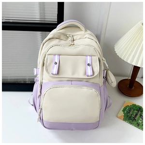 Detail of cream and purple student backpack with multi-pocket design and small coin purse