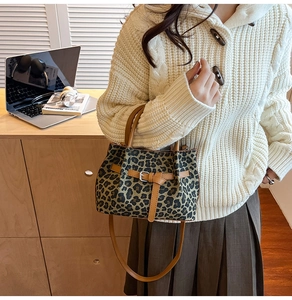 Detail der Leopard-Eimertasche mit braunen Ledergriffen und verstellbarem Schultergurt