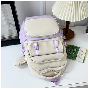 Detail of a large capacity two-tone campus backpack with multiple pockets and charms