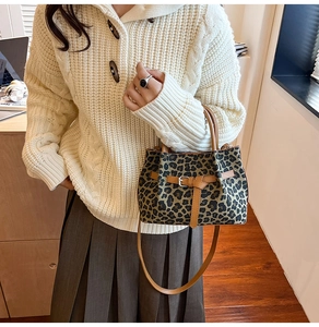 Detail der Bucket-Bag mit Leopardenmuster, braunen Lederriemen und verstellbarem Schultergurt