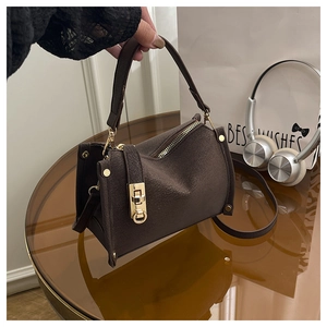 Detail of dark brown faux leather bag with metallic twist lock and gold zipper finish