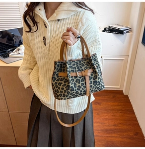 Detailansicht der Boston Bag mit Leopardenmuster, braunen Lederriemen und seitlicher Schnalle