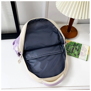 Top view of the spacious inner compartment of the cream and purple canvas backpack