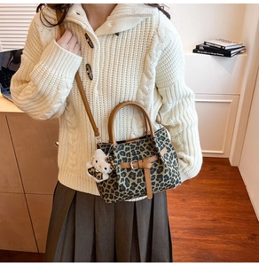 Detail der Leopardenmuster-Tasche mit Plüsch-Anhänger und Ledergriff in Premium-Optik
