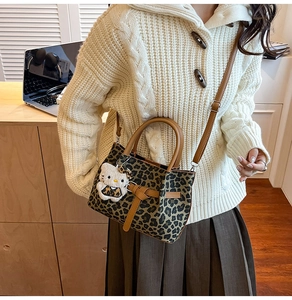 Detail der Bucket Bag mit Leopardenmuster, Lederriemen und Plüsch-Katzenanhänger für Damen