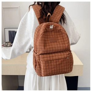 Brown corduroy checkered backpack for women shown on a model for size and style