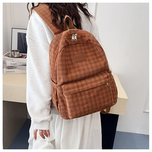 Detailed back view of a brown corduroy backpack with dual zippers and large front pocket