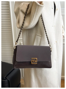 Détail du sac bandoulière gris-mauve avec texture plissée et boucle métallique dorée