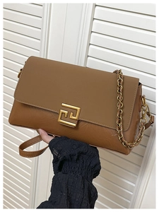 Détail du sac bandoulière en cuir marron avec boucle en métal doré et bandoulière