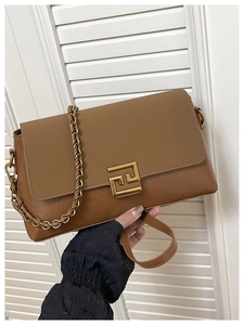 Détail d'un sac bandoulière marron bi-matière avec un fermoir géométrique doré