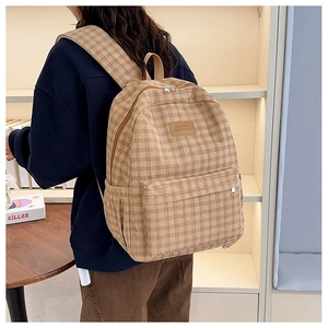 Detailed view of the vintage plaid backpack featuring high-quality fabric and leather logo tag