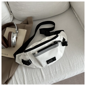 Détail du sac de sport blanc imperméable avec sangle réglable et boucle sur un canapé