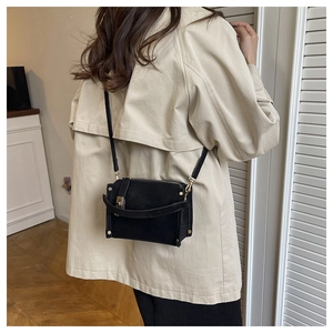 Back view of a model wearing a matte black mini square bag with gold studs and hardware