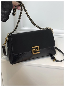 Détail du sac bandoulière noir avec rabat mat et boucle métallique dorée géométrique