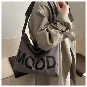 Dettaglio della borsa a tracolla in tela grigio scuro con stampa del logo MOOD. frontale