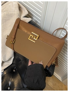 Gros plan détaillé du sac à bandoulière en cuir marron avec logo géométrique doré