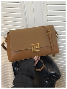 Détail du sac bandoulière vintage marron avec boucle dorée et lanière en cuir