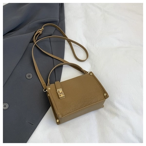 Detailed macro view of tan lychee texture leather bag with gold Gancini style clasp