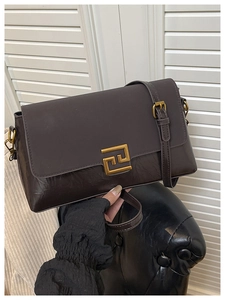 Détail du sac en cuir marron vintage avec fermoir doré géométrique et rabat texturé