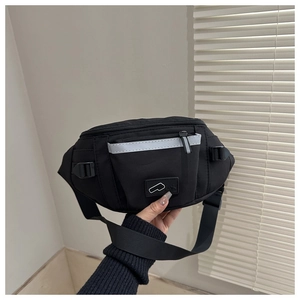 Détail du sac bandoulière en nylon avec bande réfléchissante de sécurité et boucle latérale