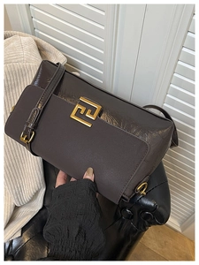 Détail du sac bandoulière marron avec boucle carrée dorée et côté en cuir texturé