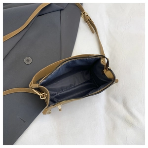 Detail shot of the interior lining and gold metal hardware of the brown crossbody bag