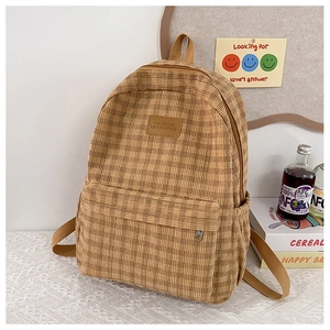 Detailed close-up of a brown plaid backpack with a textured corduroy finish and side pockets