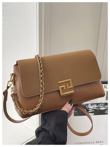 Détail d'un sac bandoulière marron avec texture plissée et boucle en métal doré