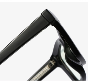 Macro detail of high-quality black frame eyeglasses hinge with polished finish