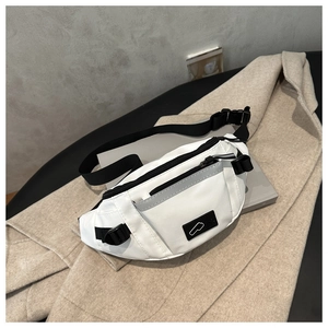 Detailed close-up of a white nylon chest bag with adjustable strap and buckle on a coat
