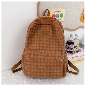 Detail of brown plaid corduroy backpack with front zipper pocket and logo patch