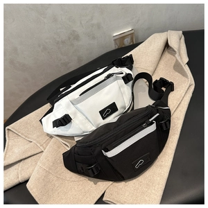 Détail de sacs banane noir et blanc avec bandes réfléchissantes sur fond neutre