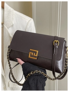 Détail du sac en cuir marron chocolat avec fermoir doré et bandoulière chaîne