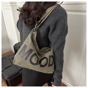 Borsa a tracolla in tela verde oliva con stampa MOOD vista da dietro sul modello