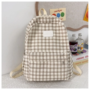 Detail of checkered canvas backpack with logo patch, multiple pockets and reinforced straps