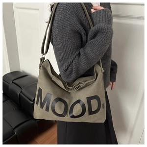 Dettaglio della borsa tote in pelle scamosciata verde oliva con scritta MOOD e tracolla