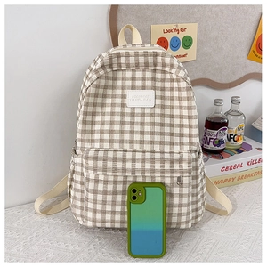 Detail of khaki plaid backpack showing durable canvas texture and front zipper pocket