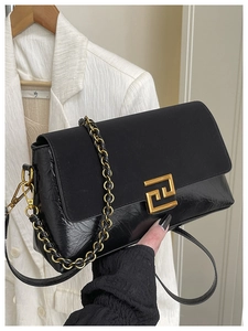 Détail du sac bandoulière noir avec texture plissée et fermoir géométrique doré