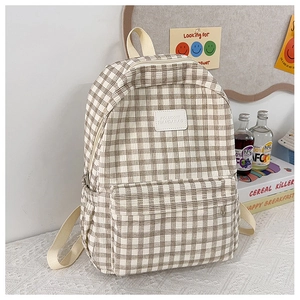 Detailed view of beige plaid backpack featuring corduroy texture and front zipper pocket