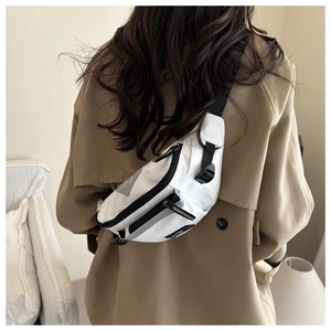 Detailed back view of a white nylon crossbody bag with reflective stripes on a model