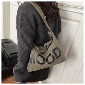 Detail of army green canvas crossbody bag featuring MOOD text and wide shoulder strap
