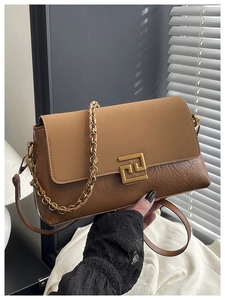 Détail du sac à main plissé marron avec boucle dorée et bandoulière en chaîne dorée